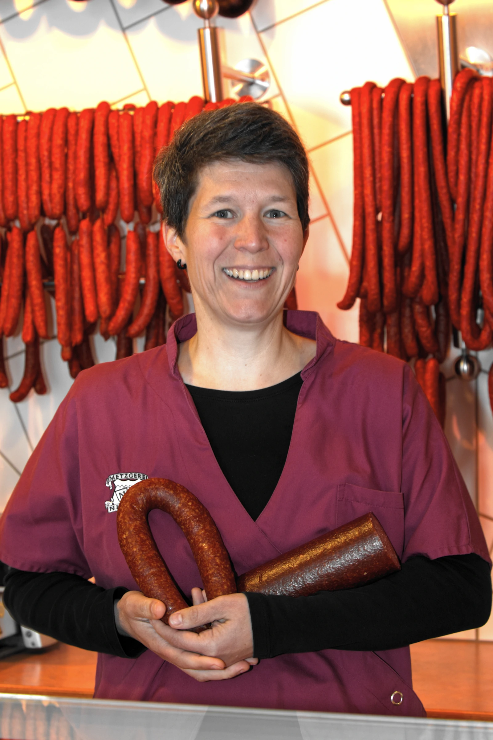 Metzgerei Nichter – Mitarbeiterin mit Saiten und Bauernbratwurst